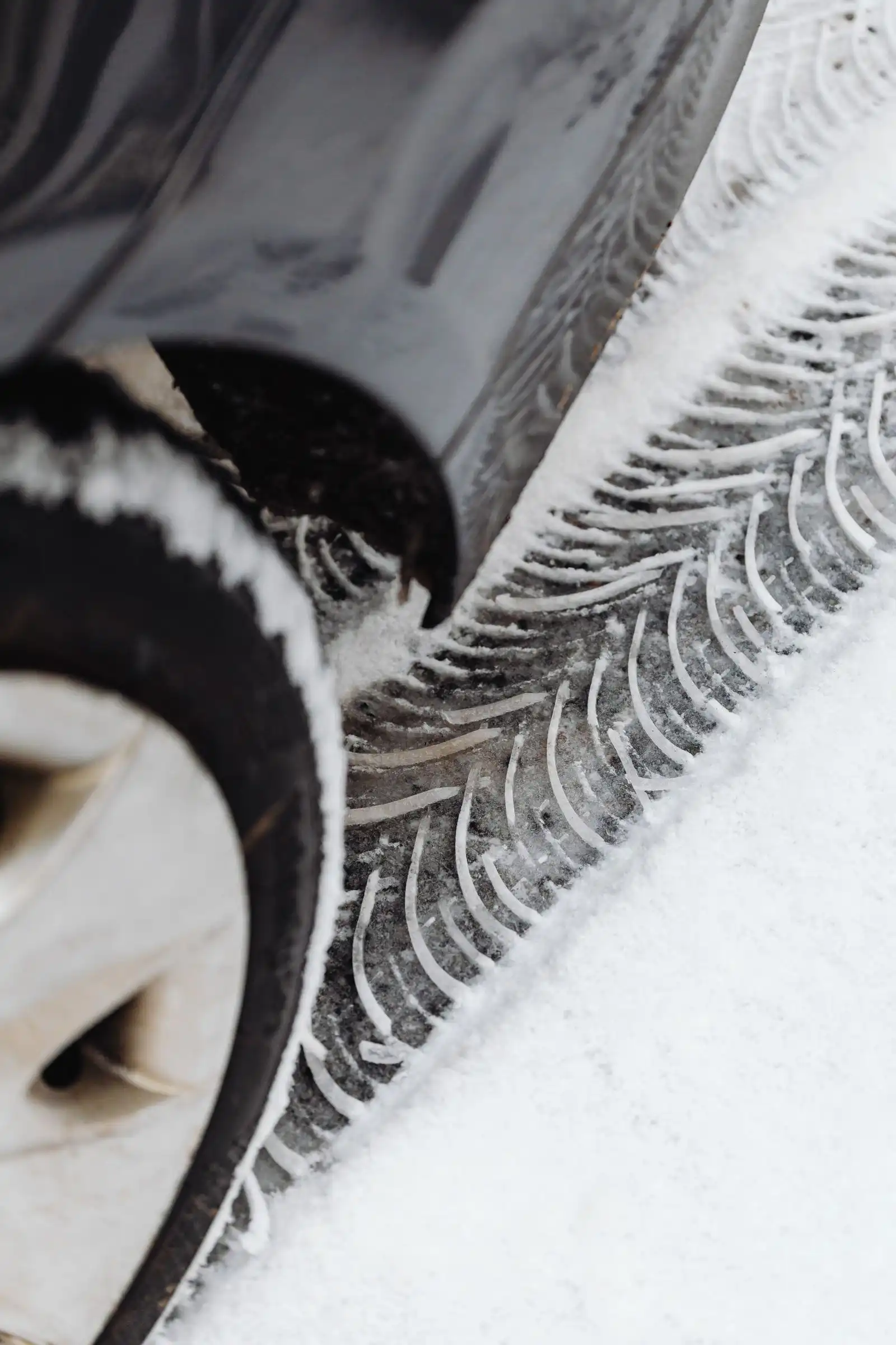 Winter tire with snow on the tread standing on snow